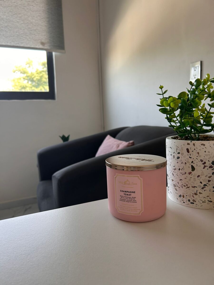 Consultorio de psicología en Guadalajara — Sala con luz natural, sofá y velas que crean un espacio cálido para terapia