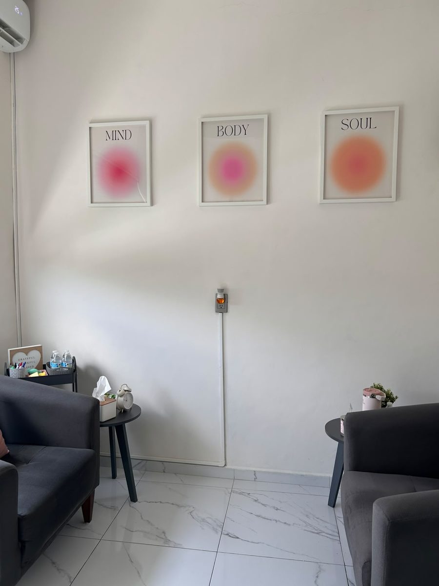 Consultorio de psicología en Guadalajara — Sala con dos sillones, mesas laterales y cuadros 